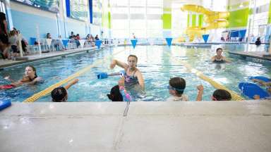 a person teaching swim lessons in a pool with kids