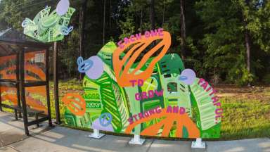Colorful, artist-designed bus shelters and a sculptural bench along Poole Road and at the Neuse River trailhead.
