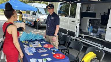 Vendor in front of mobile unit talking with community member