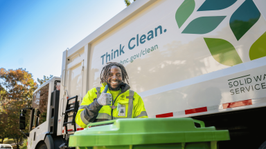 A City of Raleigh Yard Waste Collector poses outside a truck.