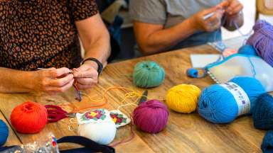 colorful yarns and hands crocheting