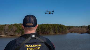 RPD officer controlling a drone flying over a lake