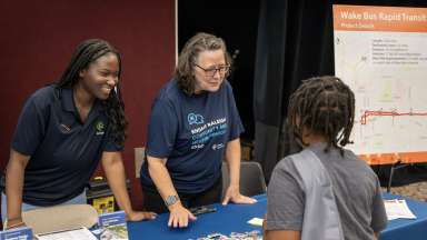 two women smiling behind table with a kid