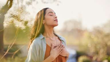 a woman focusing on breathing outside in a peaceful setting
