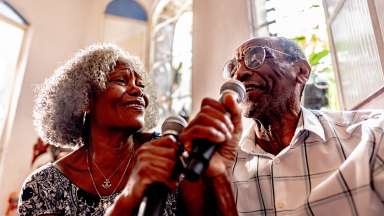 people singing into microphones and smiling