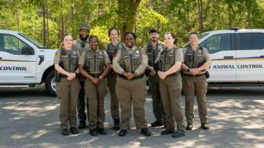 Animal Control officers standing in front of their vehicles