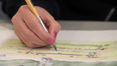 hand with pink nails painting a watercolor painting