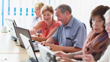 a group of adults working on laptop computers