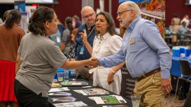 Two people shaking hands at networking event