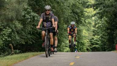 a group of people riding their bikes on a greenway trail