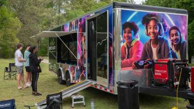the mobile recreation trailer with young people playing games outside