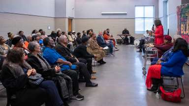 a large room with people seated while listening to a speaker