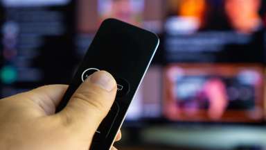 a hand holding a tv remote