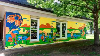 A brightly colored mural depicting pedestrians and cyclists