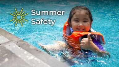 Child in pool wearing life jacket