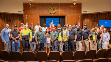 Solid Waste Services staff pose in the council chambers following the proclamation of Waste and Recycling Workers Week.
