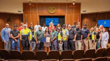 Solid Waste Services staff pose in the council chambers following the proclamation of Waste and Recycling Workers Week.