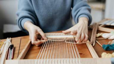 a person using a weaving loom