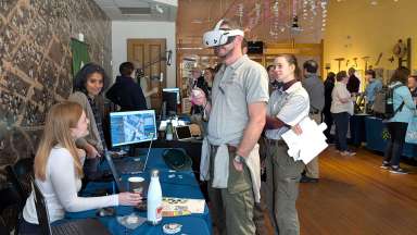 Event participant using virtual reality to learn more about GIS technology during the GIS Day event.