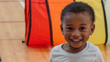 a young child smiling in a gymnasium