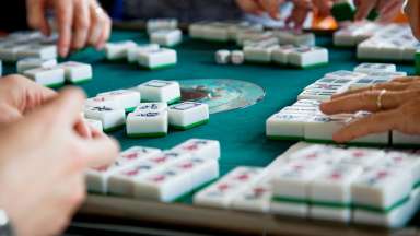 a card table with people playing american mahjong