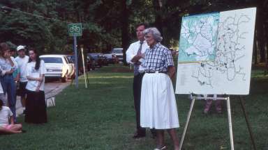 as vintage photograph of people outdoors showing the greenway map to the public