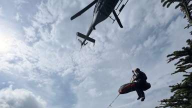 A raleigh firefighter is lowered by a helicopter