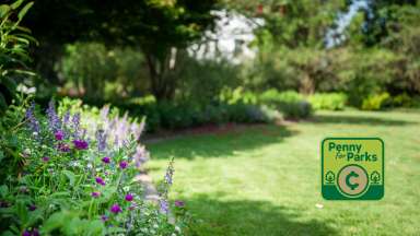 a garden image with a small square badge at the bottom right that says "penny for parks" with a coin in the middle