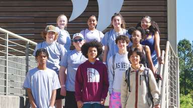 a group of teens on an outdoor stairway smiling