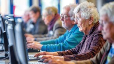 a group of senior citizens working on desktop computers