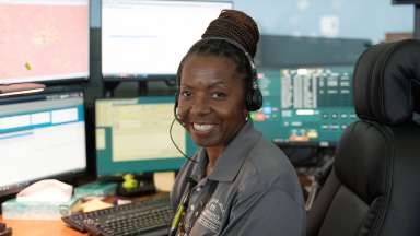 911 call taker with headset sitting in front of computer screen