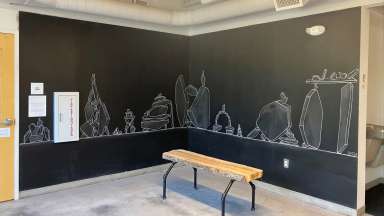 Corner chalk wall with white chalk drawings of piles of rocks