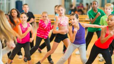 diverse group of children participating in a dance fitness class