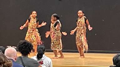 children on stage doing African dancing