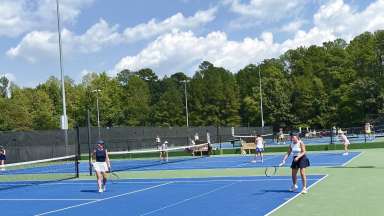 adults playing tennis on an outdoor court