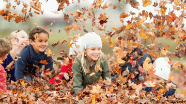 Kids playing in a pile of leaves