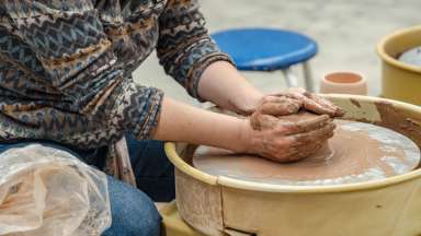 Woman throwing a pot on the wheel