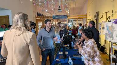 Visitors at the 2025 GIS Day event discuss using GIS technology.