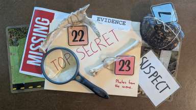clues and signs from a crime scene - magnifying glass, folder with the words "top secret" and "photos from the scene"