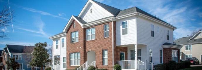 Apartment building with brick and white vinyl siding exterior