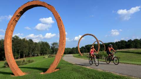 couples on bikes art museum trail near gyre sculpture