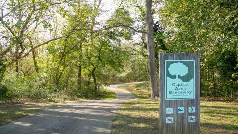 Part of the greenway and a sign with rules on it