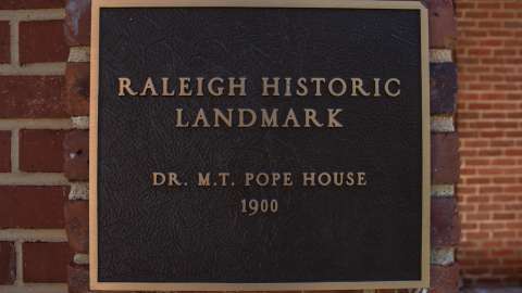 A shot of the "Raleigh Historic Landmark" placard outside the Pope House