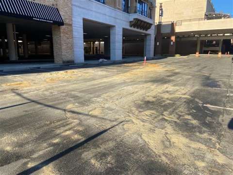 An overflow from a manhole in the parking lot of fats, oils, and grease that clogged the sewer system.