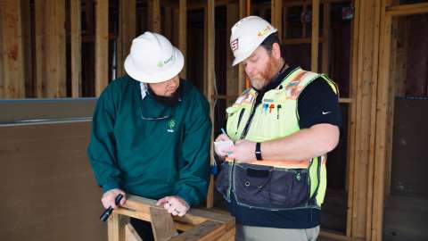 Two inspectors in a construction home making sure the building is safe.