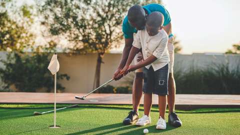 image of father teaching son how to putt