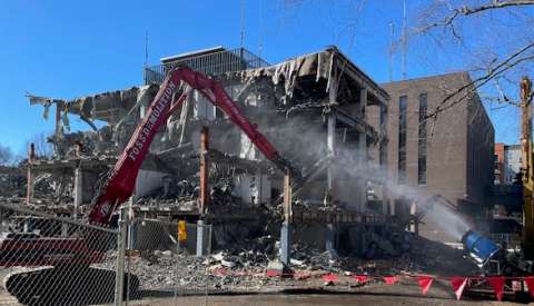 large equipment taking down inner walls of the old police station, photo taken from McDowell St side of building