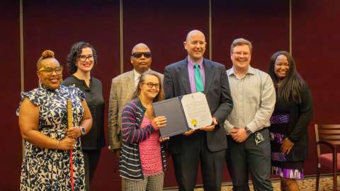 mayor's committee for persons with disabilities committee members holding signed proclamation document