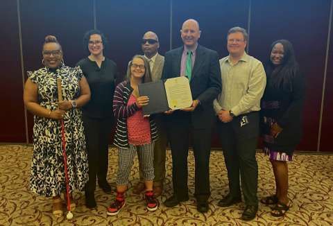 mayor's committee for persons with disabilities committee members holding signed proclamation document