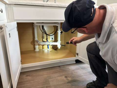 City of Raleigh inspector checking plumbing under kitchen sink for the Home Builders Blitz 2024